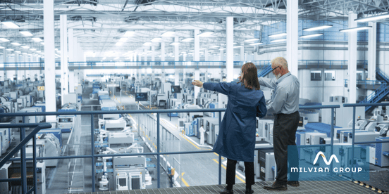 Experienced Male and Female Engineers Standing on a Platform with Their Back to Camera, Using Laptop Computer and Discussing Production at a Modern AI Automated Electronics Manufacturer